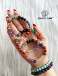 Hand holding colorful 7 chakra healing crystal bracelets for energy balance spiritual growth and chakra alignment
