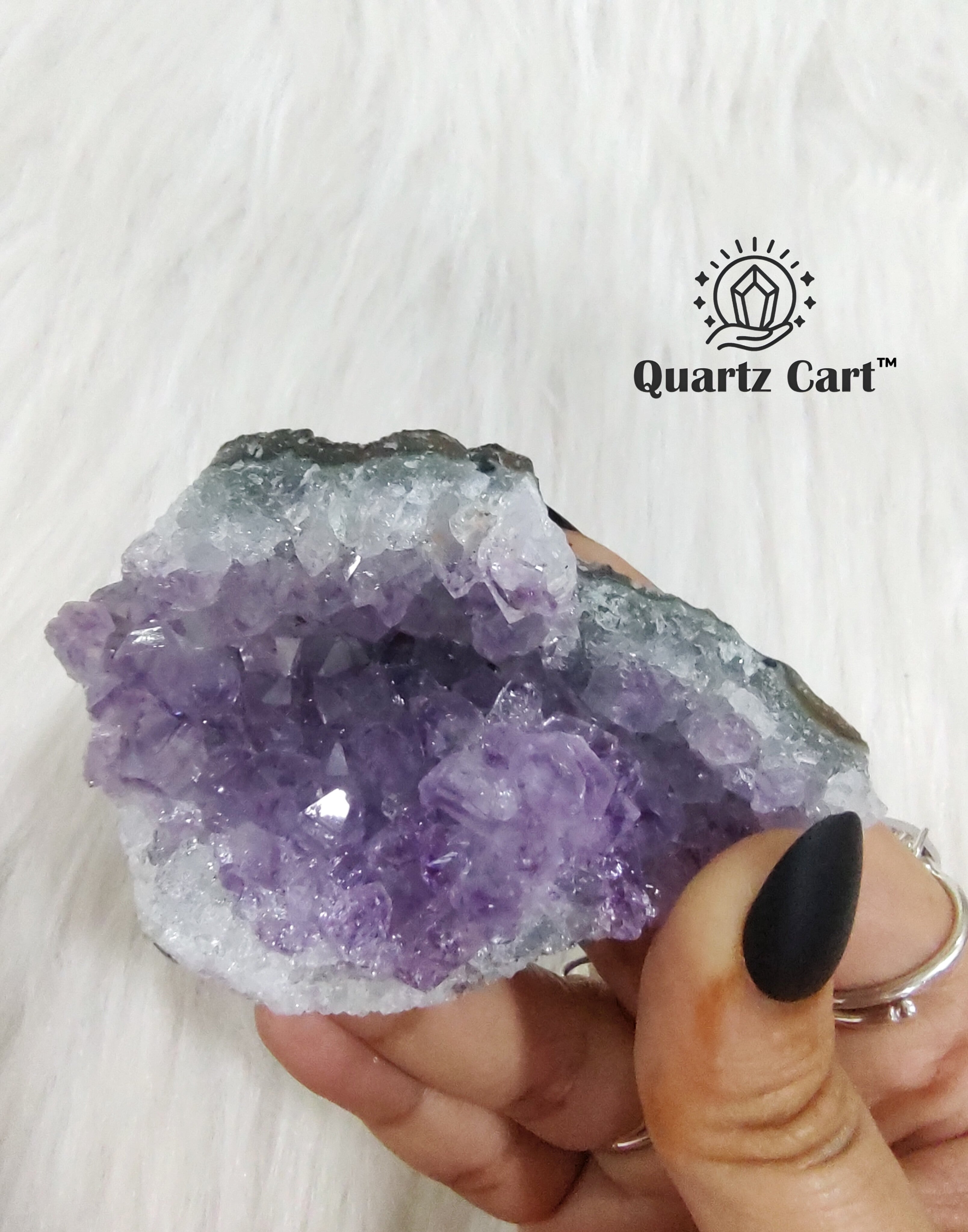 Natural Amethyst crystal cluster medium #02 held in hand showing raw purple crystal points for healing and meditation.