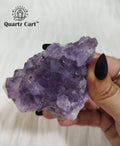 Natural Amethyst crystal cluster medium #04 held in hand showing raw purple crystal points for meditation and spiritual healing.