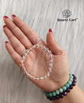 Hand holding Angel Aura Quartz healing crystal bracelet 8mm for positivity spiritual energy and aura cleansing