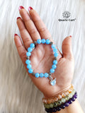 Aquamarine charms bracelet held on hand showing natural light blue gemstone beads, crystal bracelet for clarity, peace and emotional balance