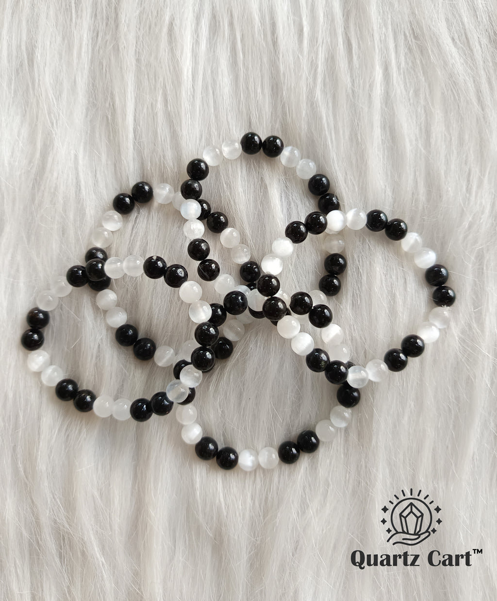Multiple black tourmaline and selenite aura cleanser bracelet placed on white background for energy protection and aura cleansing
