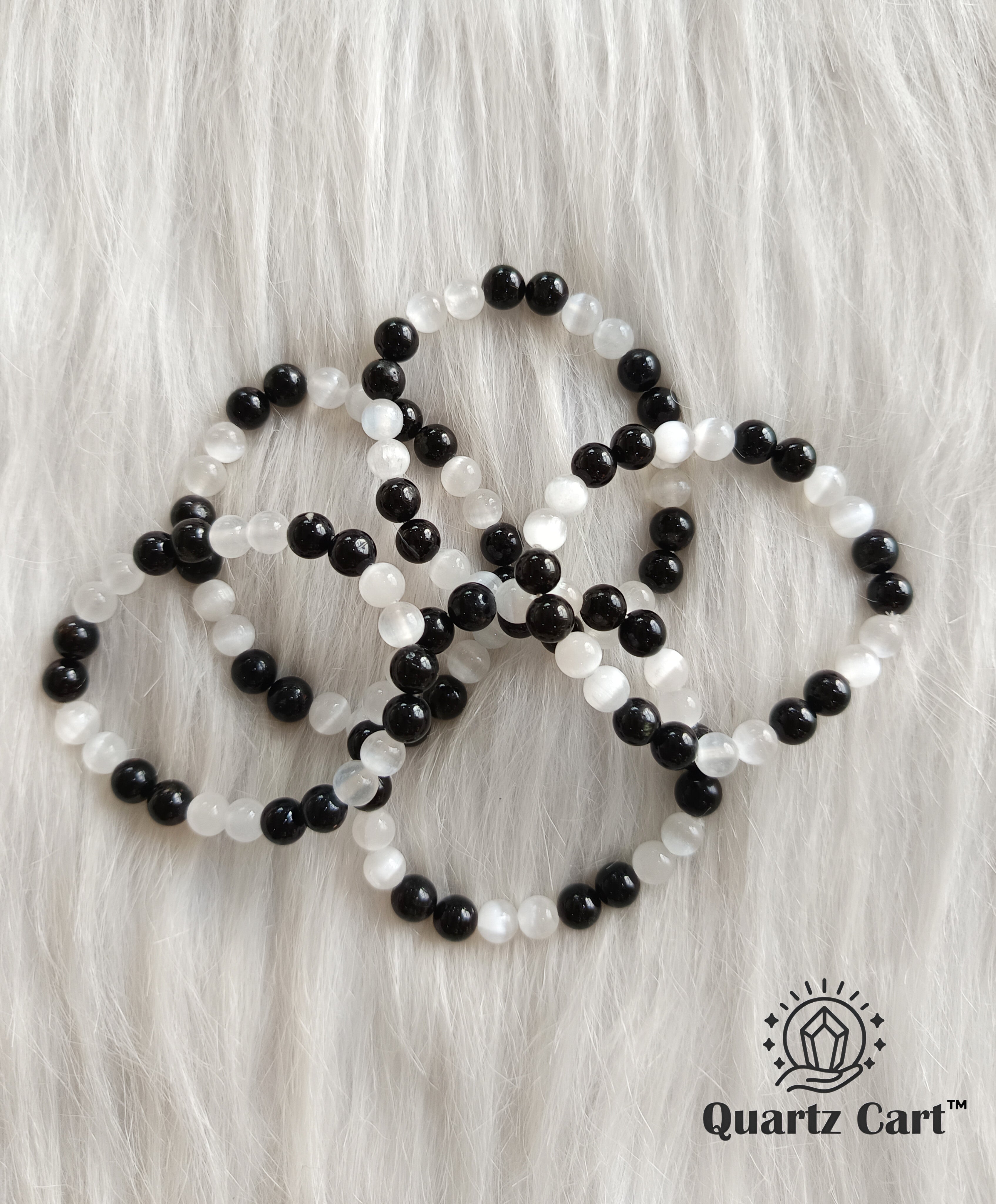 Multiple black tourmaline and selenite aura cleanser bracelet placed on white background for energy protection and aura cleansing