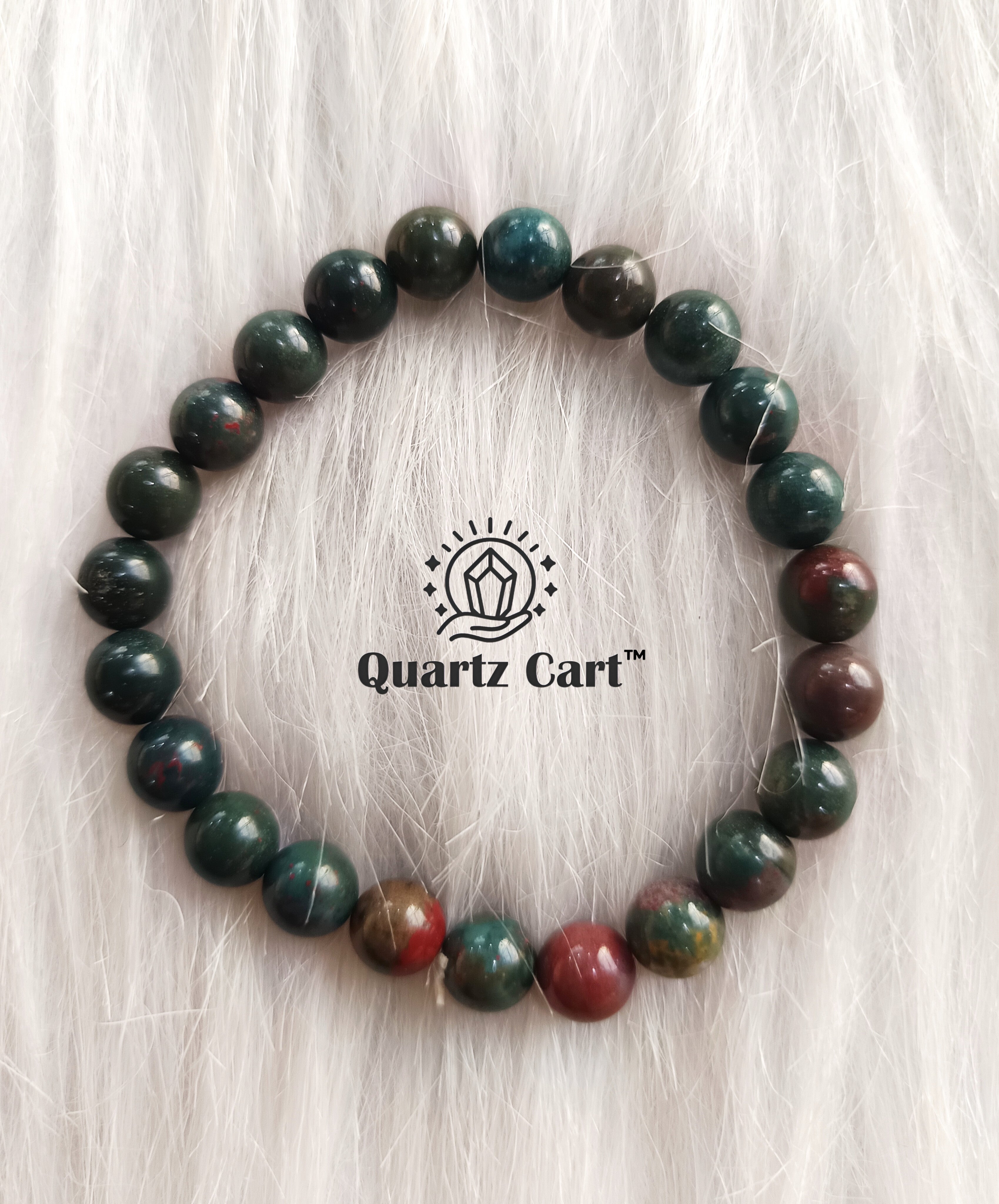 Bloodstone round bracelet displayed on soft surface showing green and red natural gemstone beads, healing crystal bracelet for strength and protection