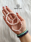 Two cinnabar bracelets held on hand displaying natural red crystal beads, gemstone bracelet for wealth attraction, success and positive energy