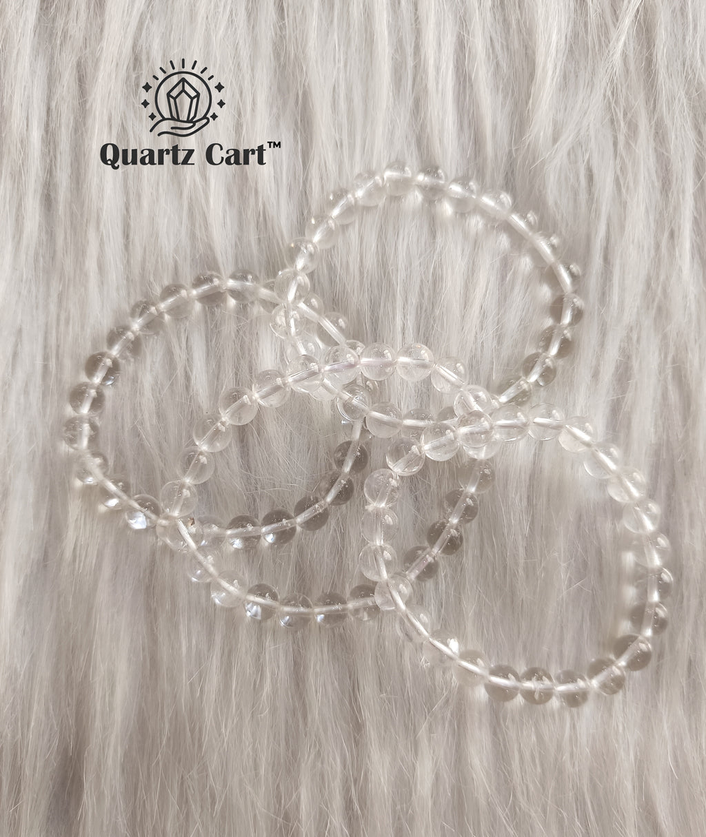 Clear quartz bracelet flat lay on surface showing transparent gemstone beads, healing crystal for clarity, focus and emotional balance