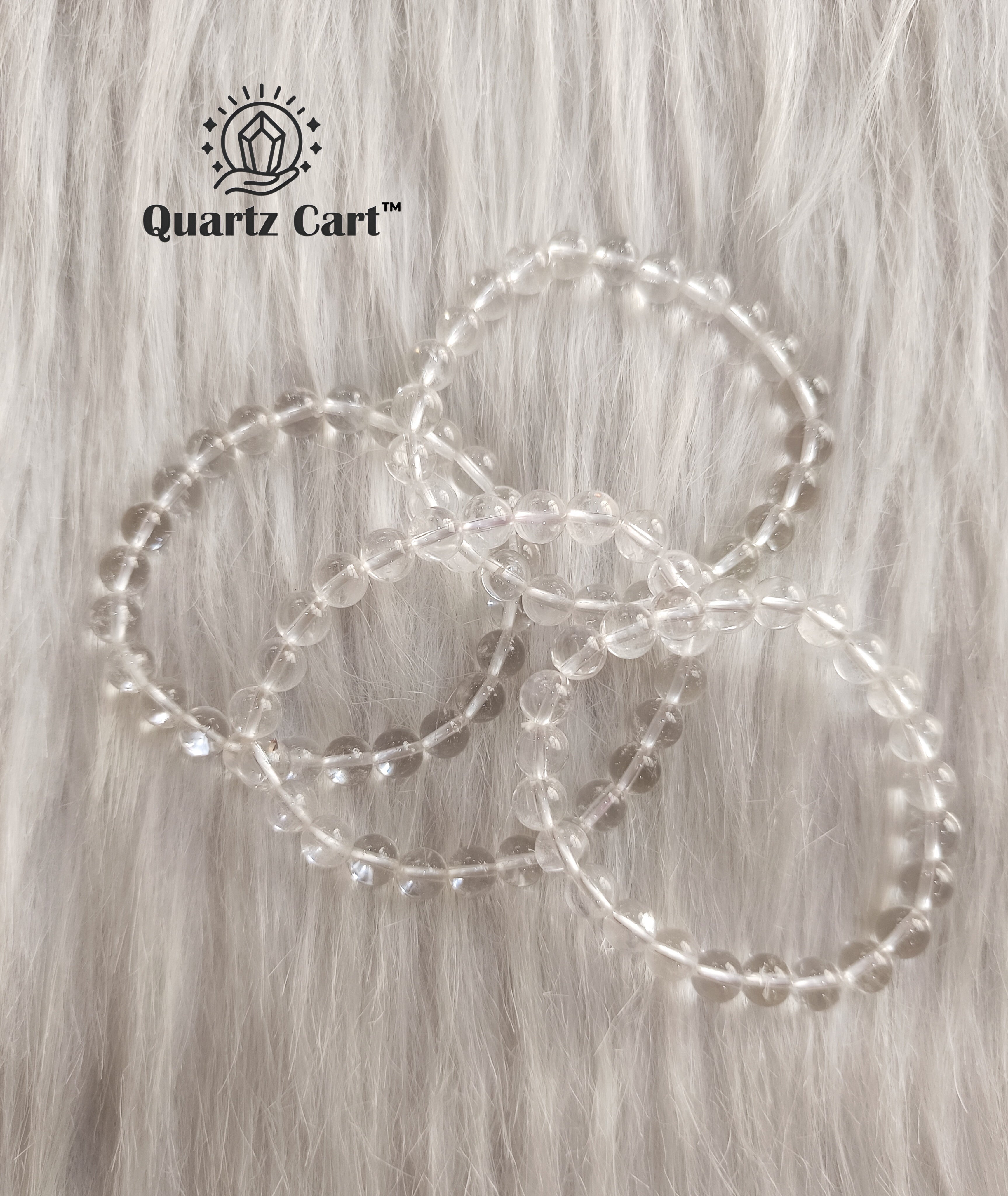 Clear quartz bracelet flat lay on surface showing transparent gemstone beads, healing crystal for clarity, focus and emotional balance