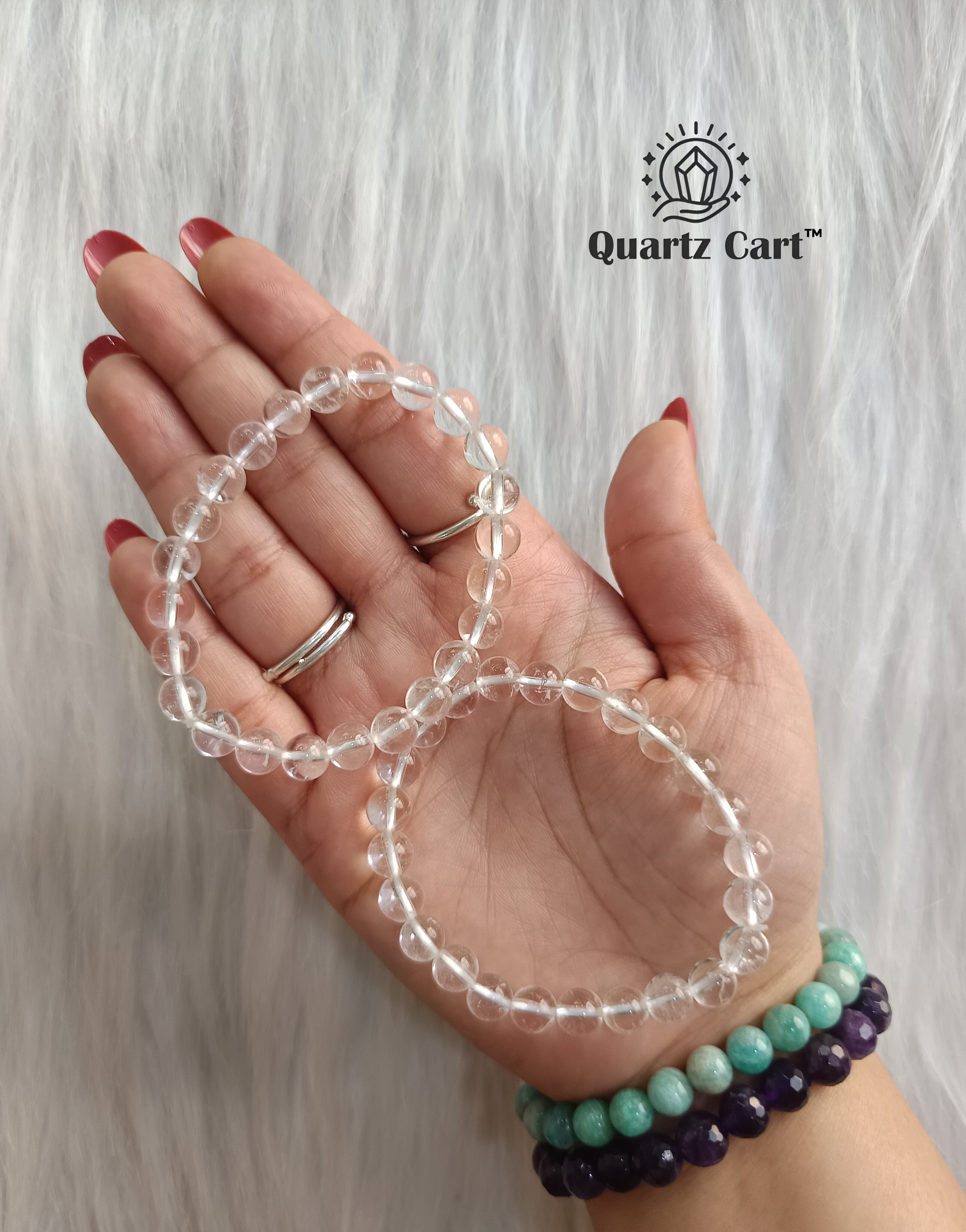 Two clear quartz bracelets placed on palm showing natural crystal beads, healing bracelet for clarity, energy amplification and positivity
