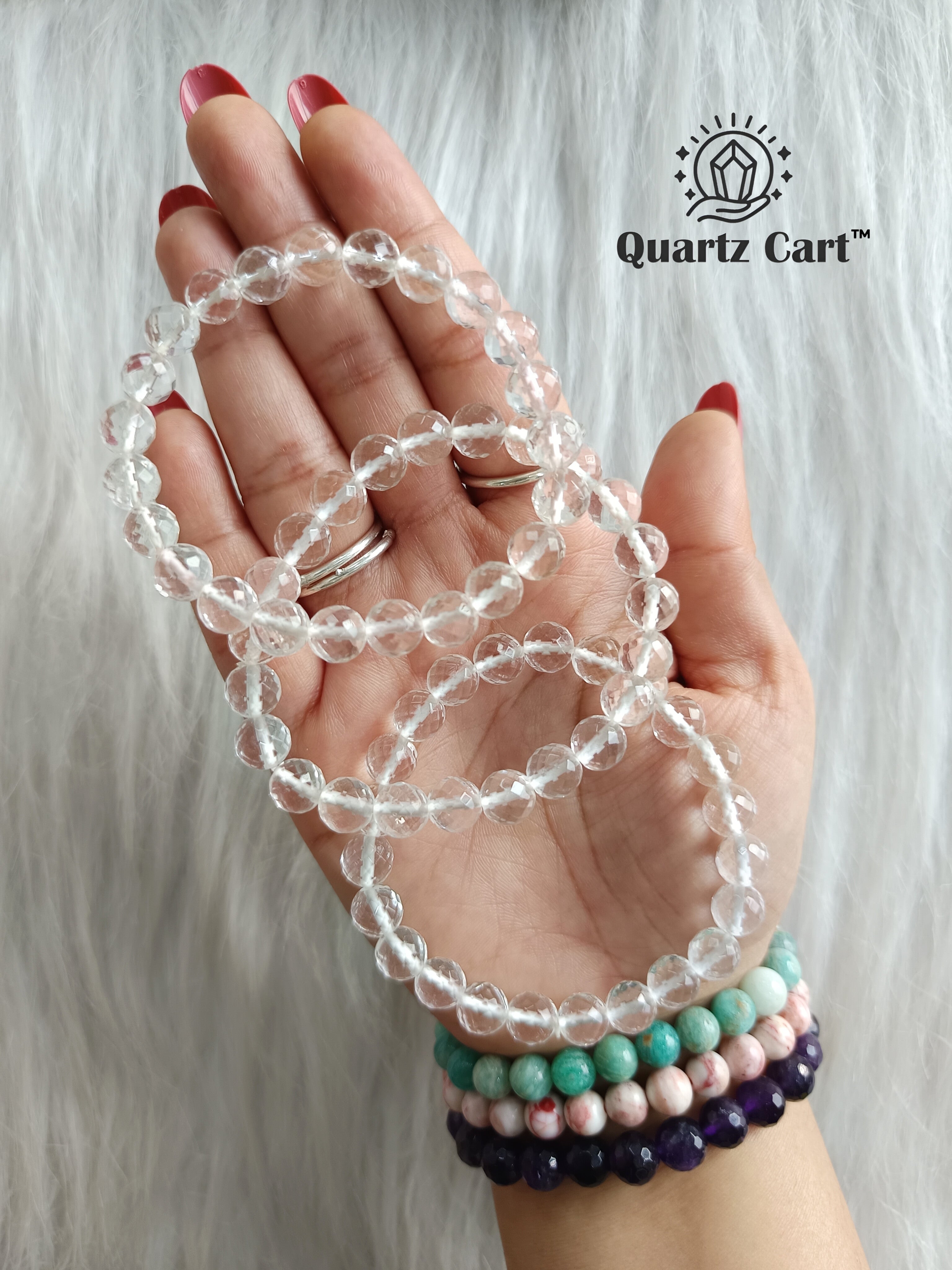 Hand holding Clear Quartz faceted healing crystal bracelets for clarity energy amplification and spiritual balance