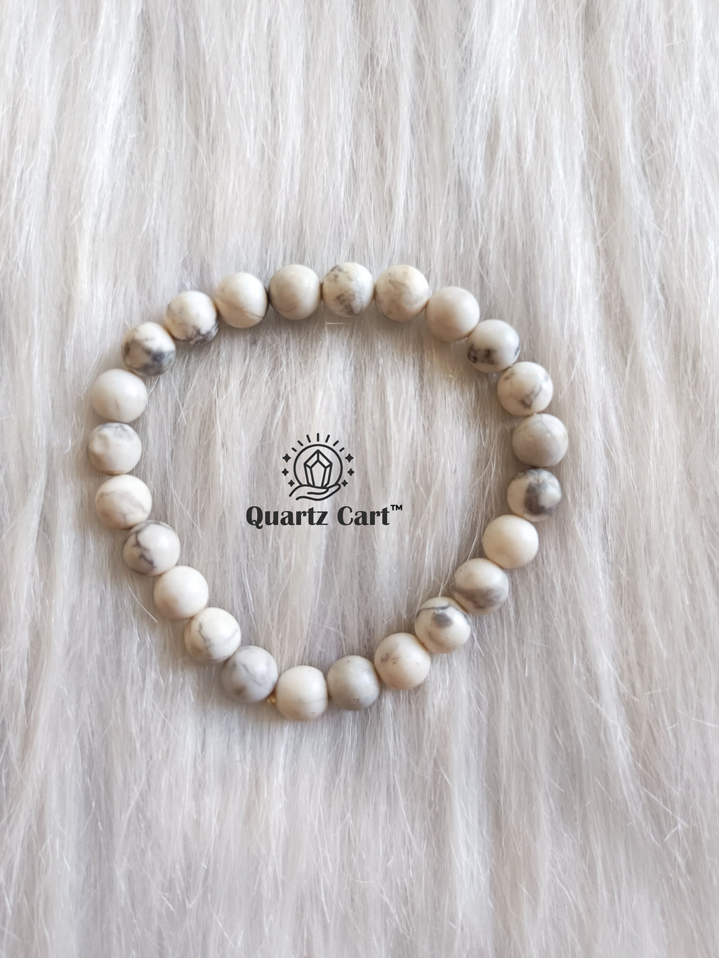 Howlite bracelet displayed on surface showing white gemstone beads with grey veins, healing crystal bracelet for calmness, stress relief and emotional balance