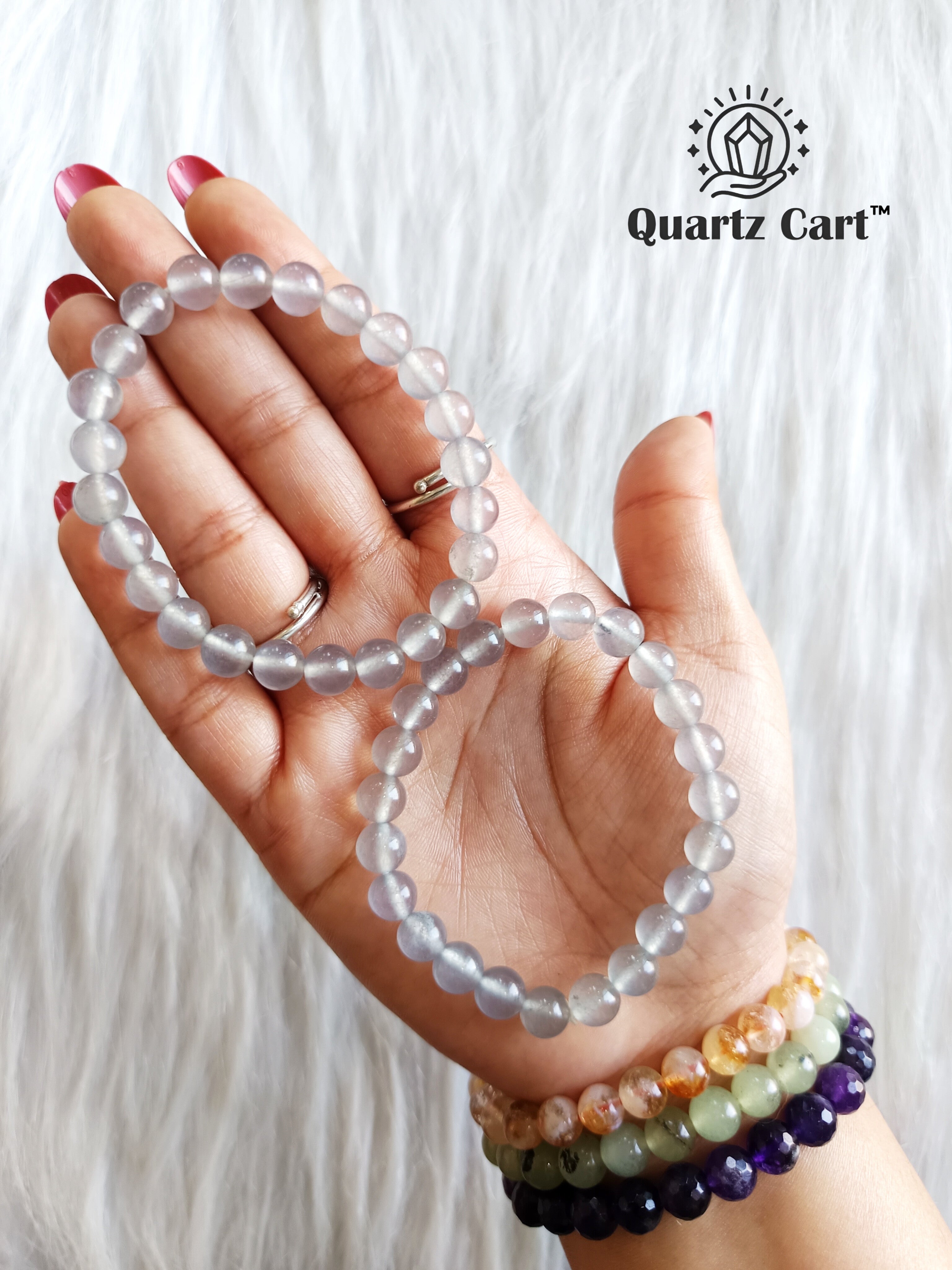 Iolite bracelets held on hand showing natural violet gemstone beads, crystal bracelet for intuition, focus and spiritual awareness