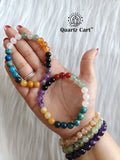 Women wearing multi crystal knee support healing bracelet with colorful beads for joint comfort and energy balance.