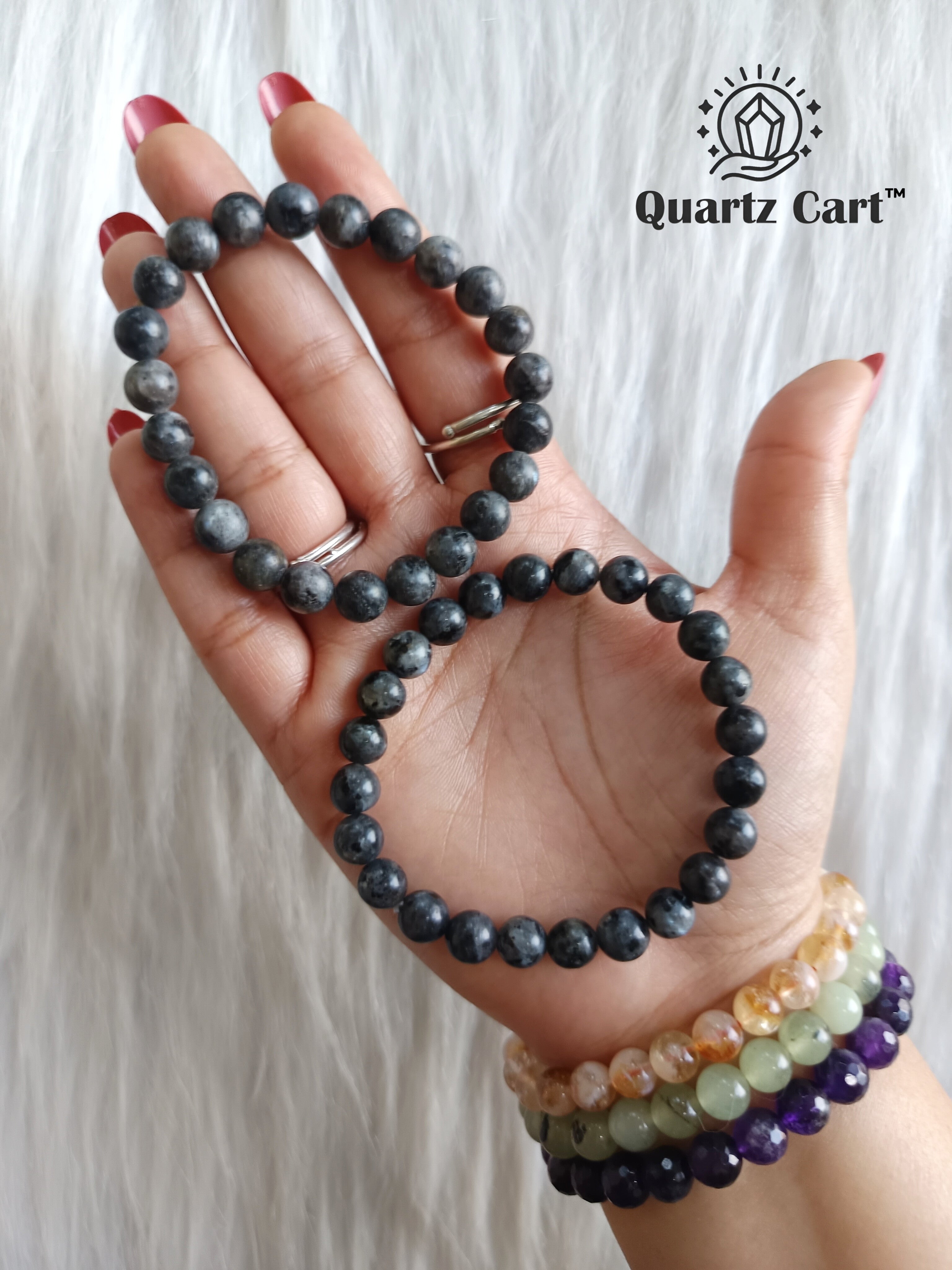 larvikite bracelet on hand showing natural dark gemstone beads for protection grounding and mental clarity