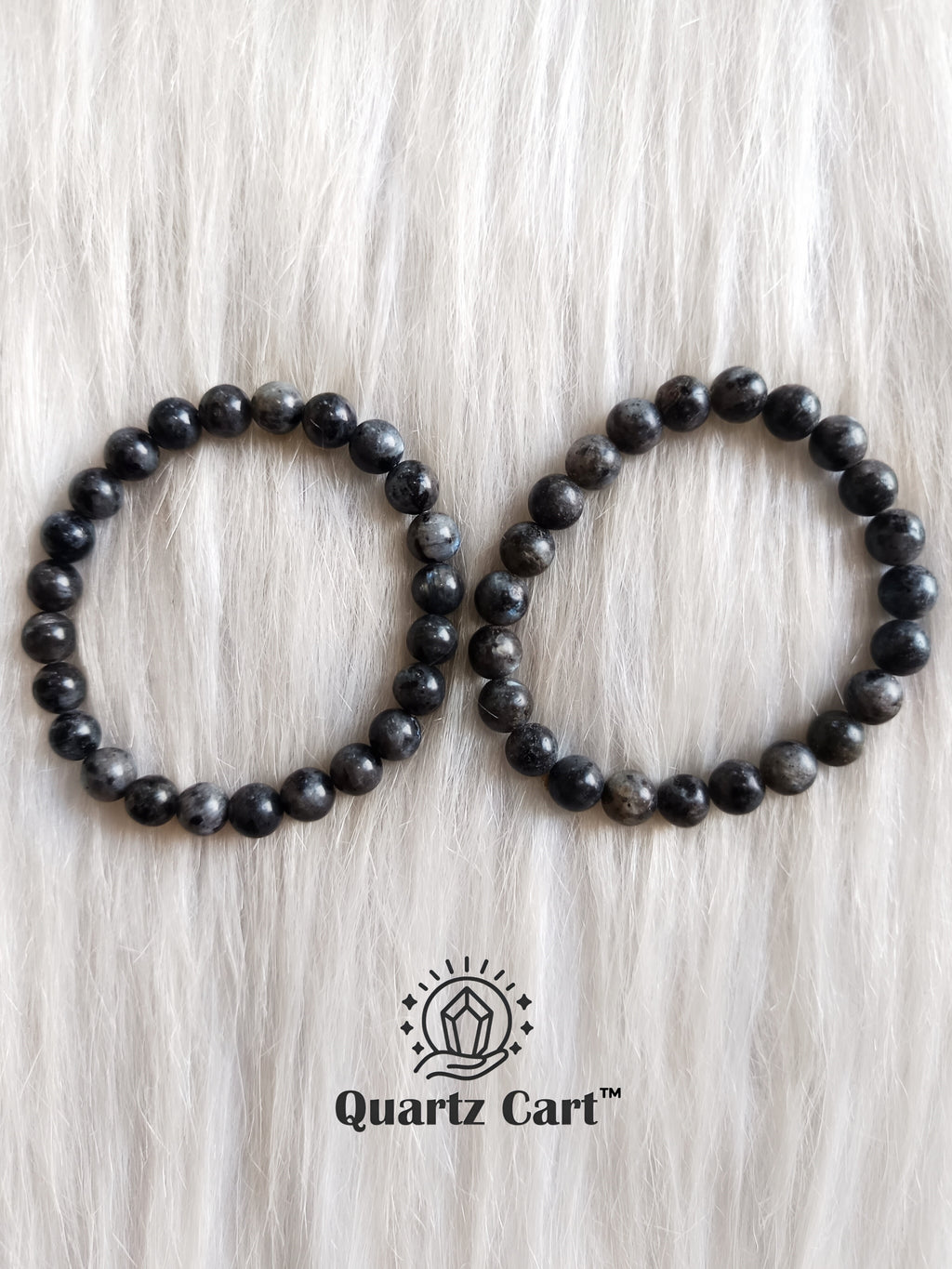 two larvikite crystal bracelets placed on surface showing polished beads for energy protection and emotional balance