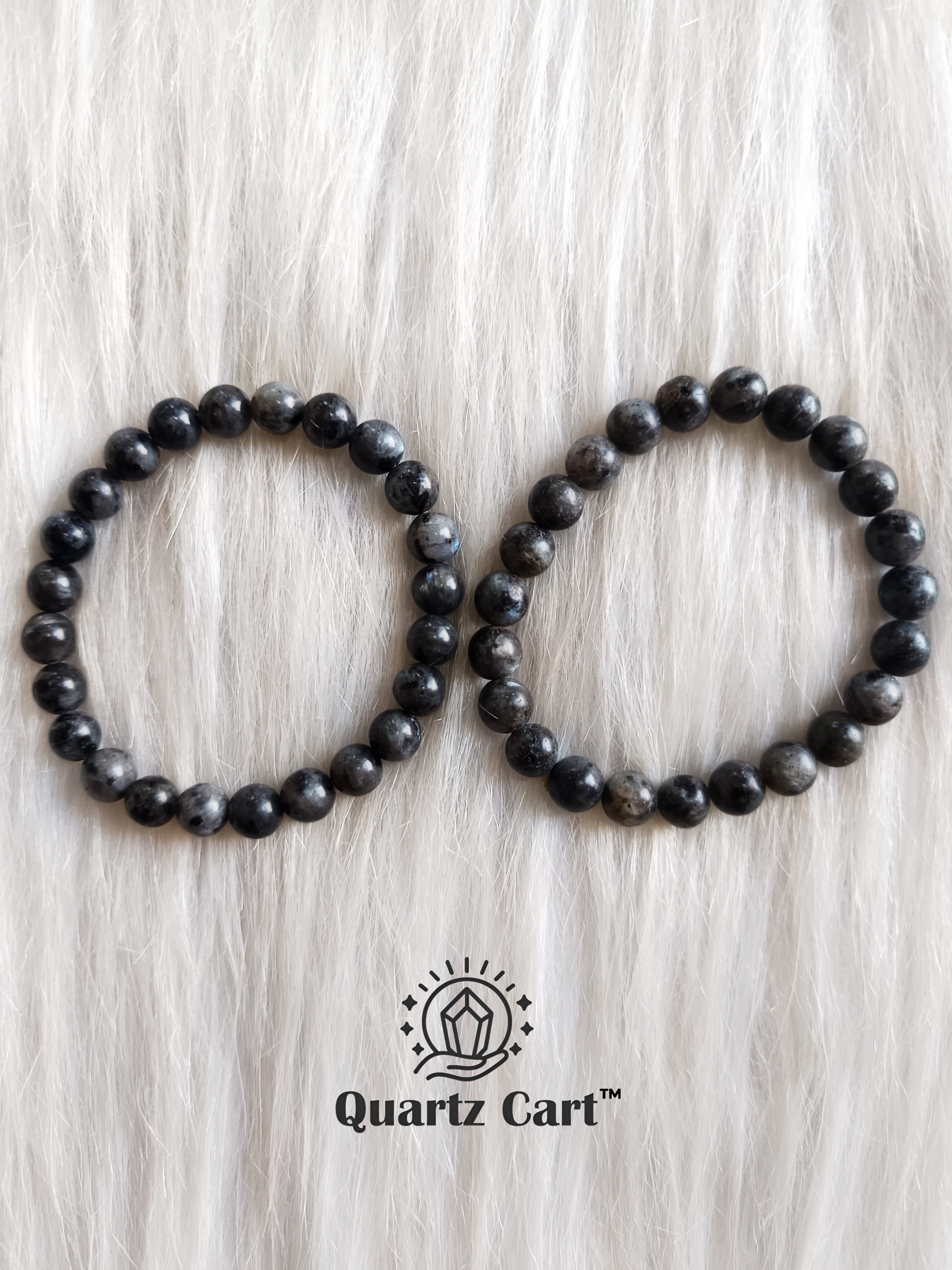 two larvikite crystal bracelets placed on surface showing polished beads for energy protection and emotional balance