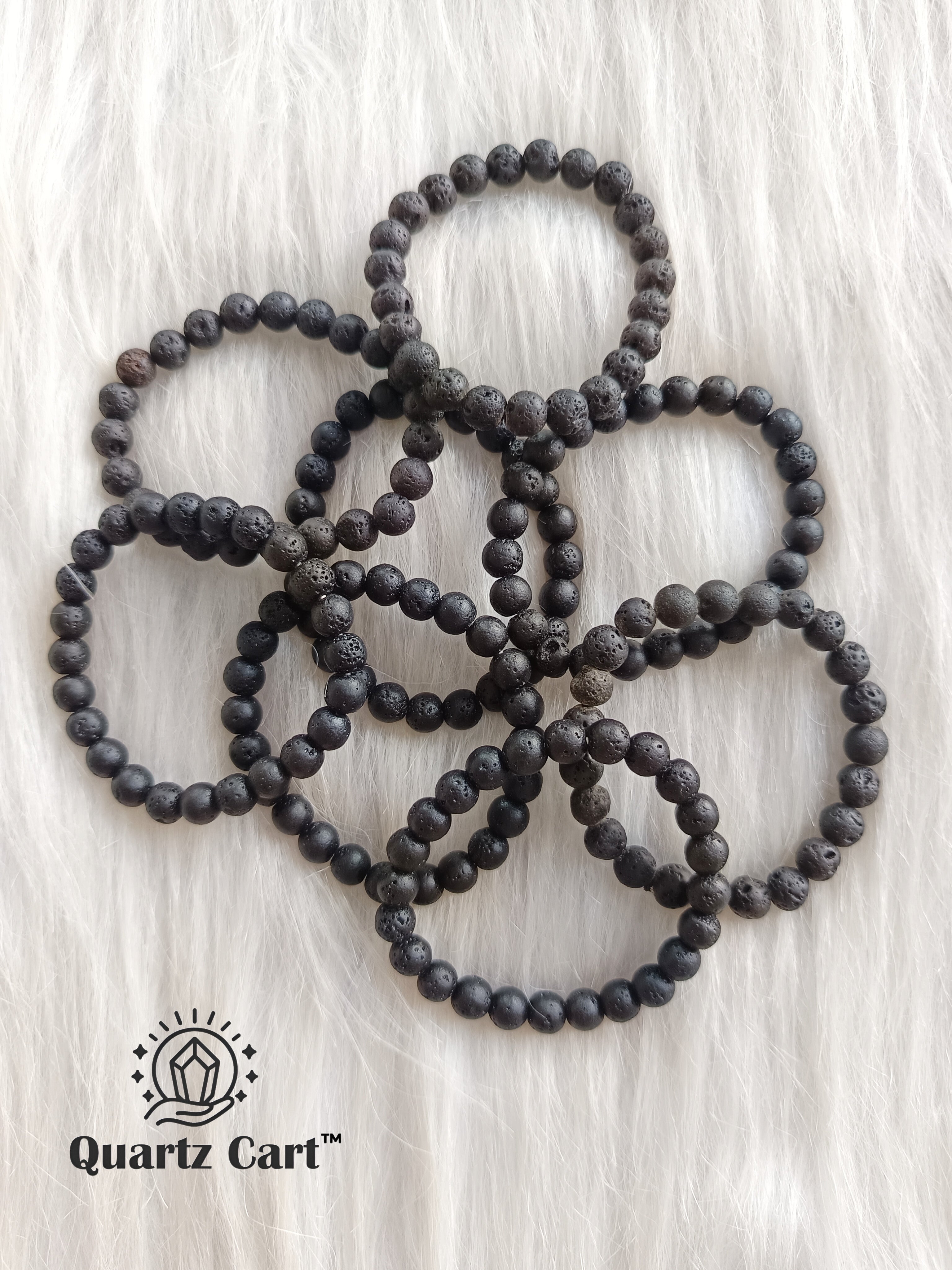 Black lava stone bracelet placed on floor showing natural porous beads for grounding, emotional balance and essential oil use