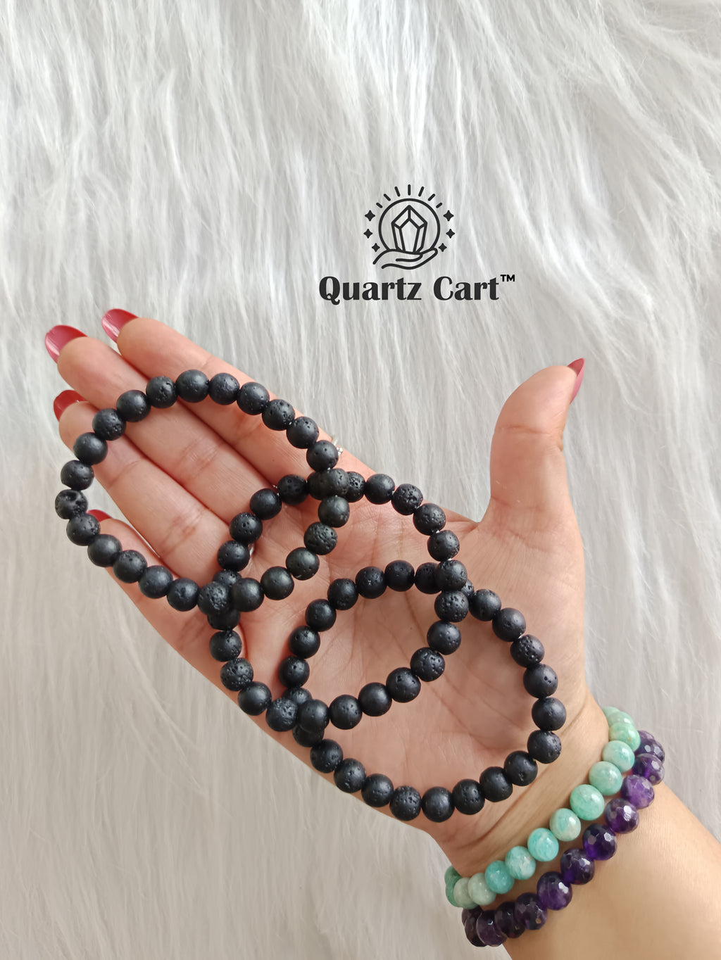 Hand holding natural Lava stone healing bracelets for grounding strength and energy balance