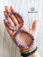 Hand holding Lepidolite healing crystal bracelet for stress relief calmness and emotional balance