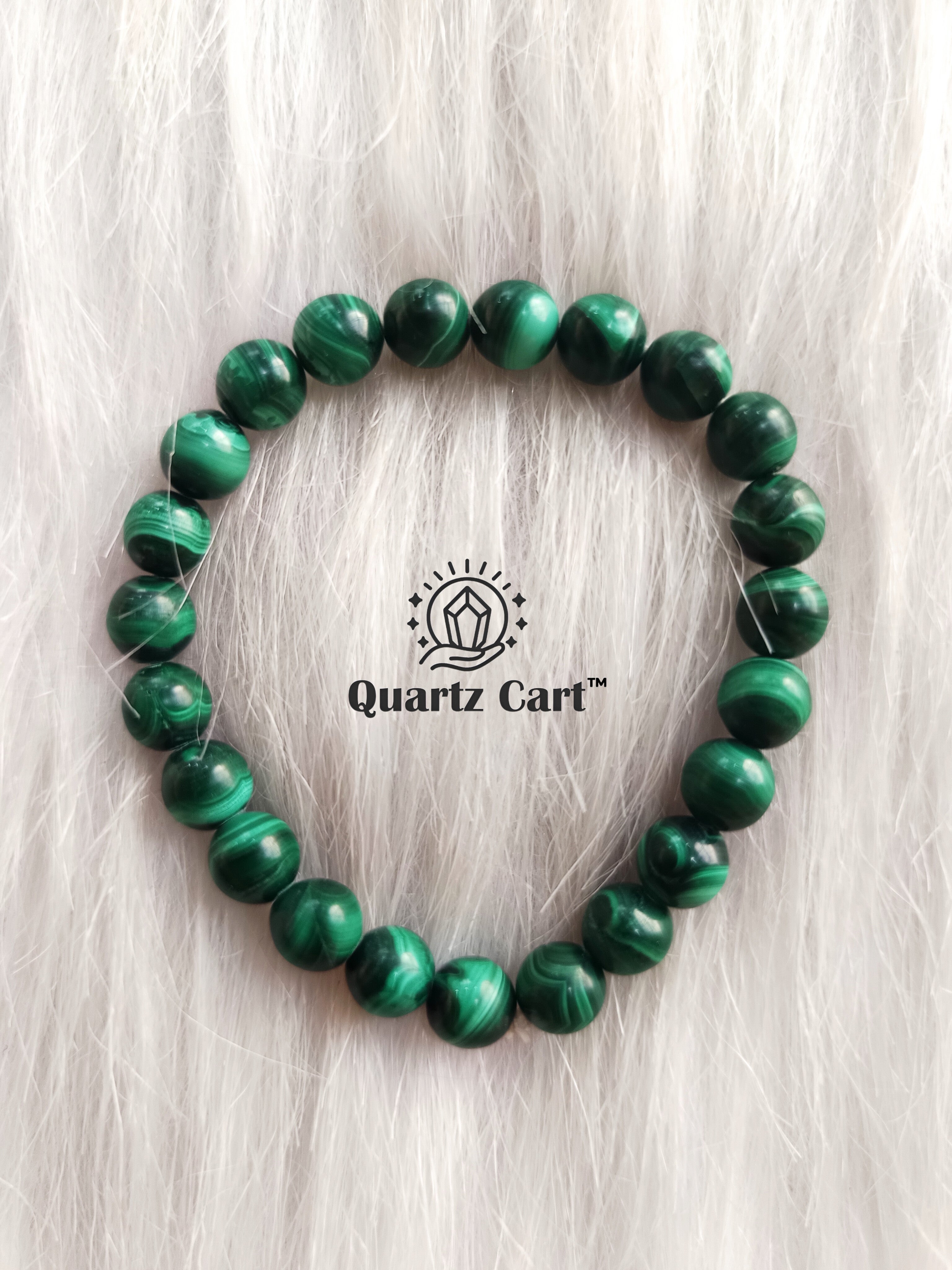 Malachite bracelet displayed on surface with natural green gemstone beads, healing crystal bracelet for protection, transformation and emotional balance