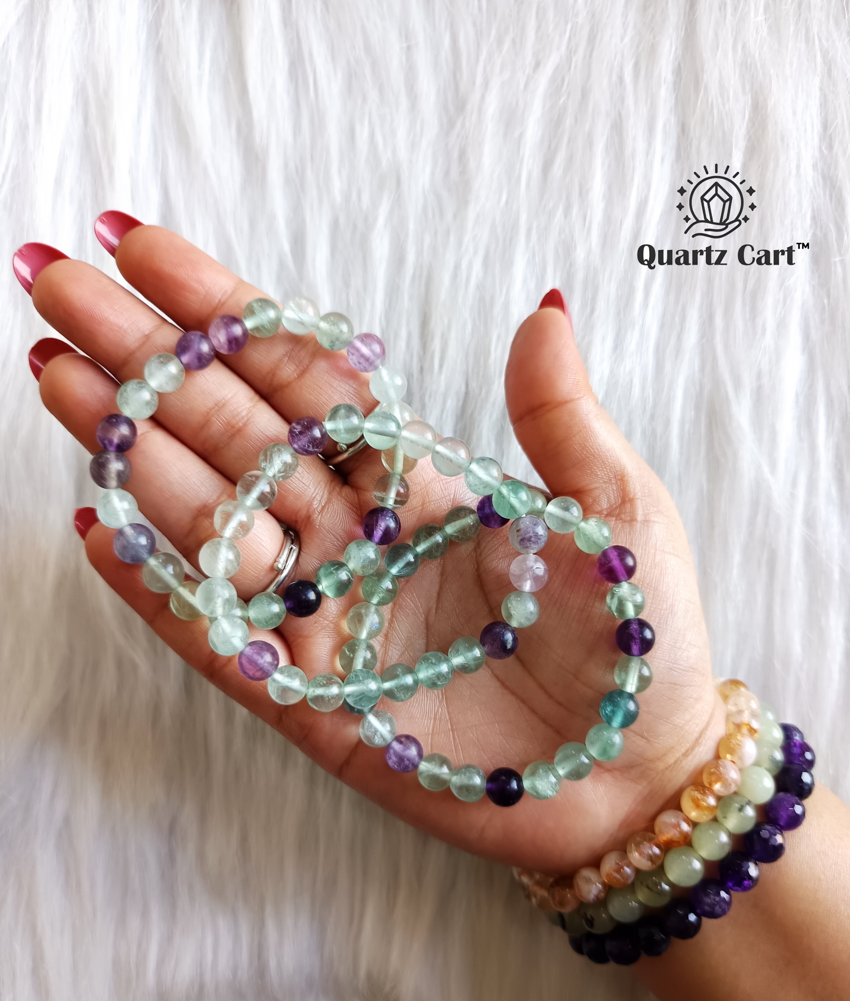 Multiple multi fluorite bracelets held on hand showing colorful natural gemstone beads, crystal bracelet for focus, clarity and emotional balance