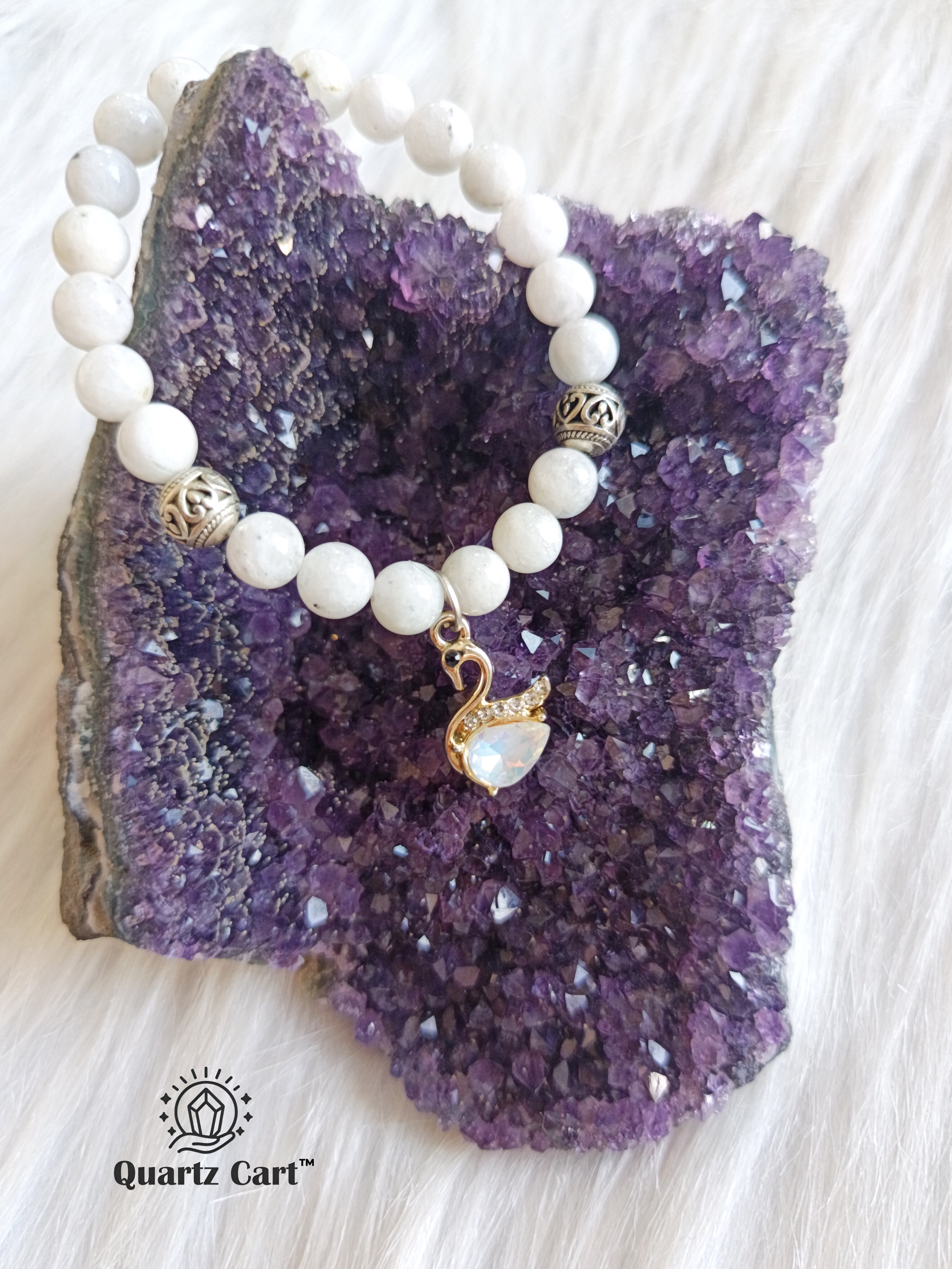 Rainbow moonstone charms bracelet displayed on surface with natural white gemstone beads, healing crystal bracelet for intuition and emotional balance