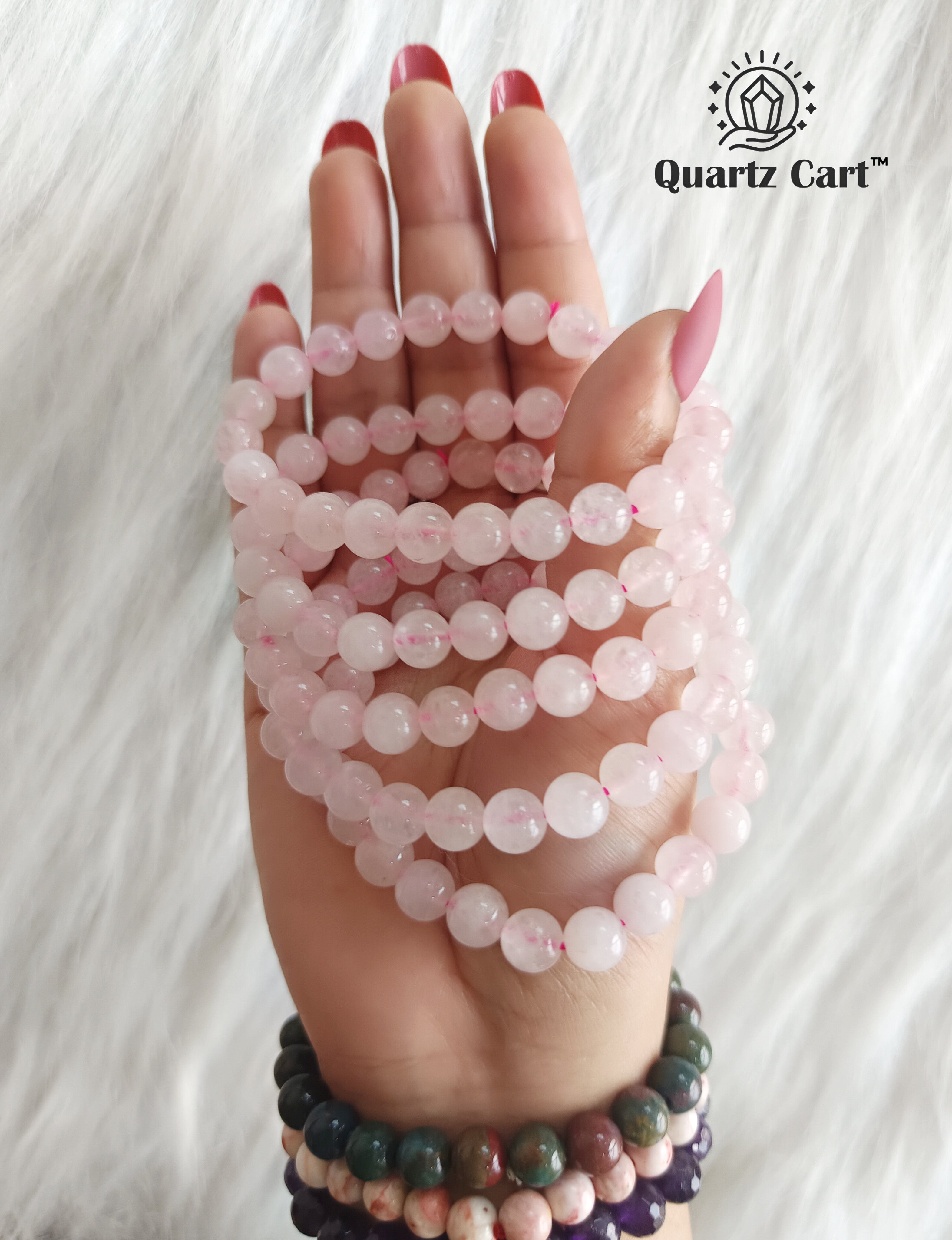 Hand displaying Rose Quartz crystal bracelets for self love emotional healing and positive energy