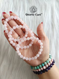 Hand holding Rose Quartz faceted healing crystal bracelet for love emotional healing and heart chakra balance