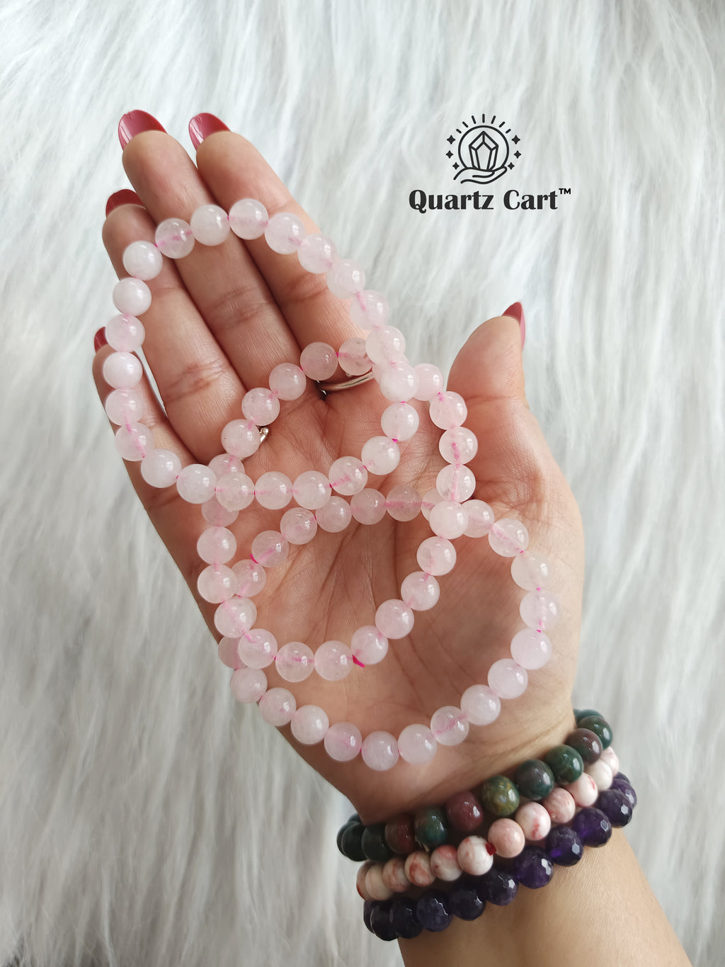 Hand holding natural Rose Quartz healing crystal bracelets for love emotional healing and heart chakra balance