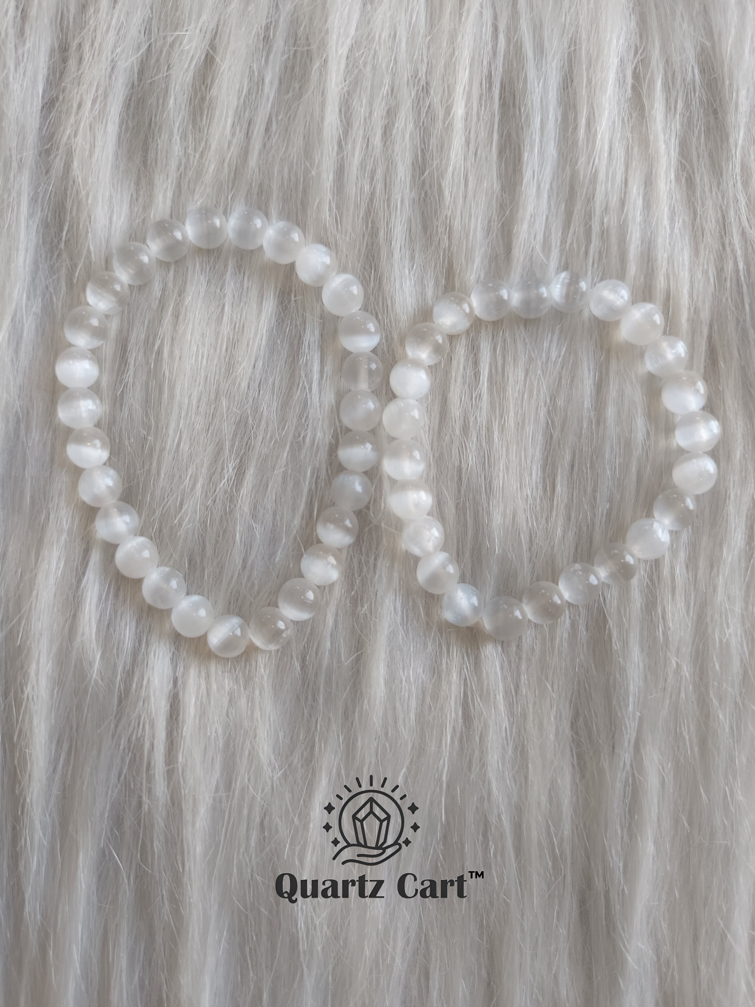 Two selenite crystal bracelets on soft surface showing milky white gemstone beads, spiritual bracelet for peace, clarity and aura cleansing