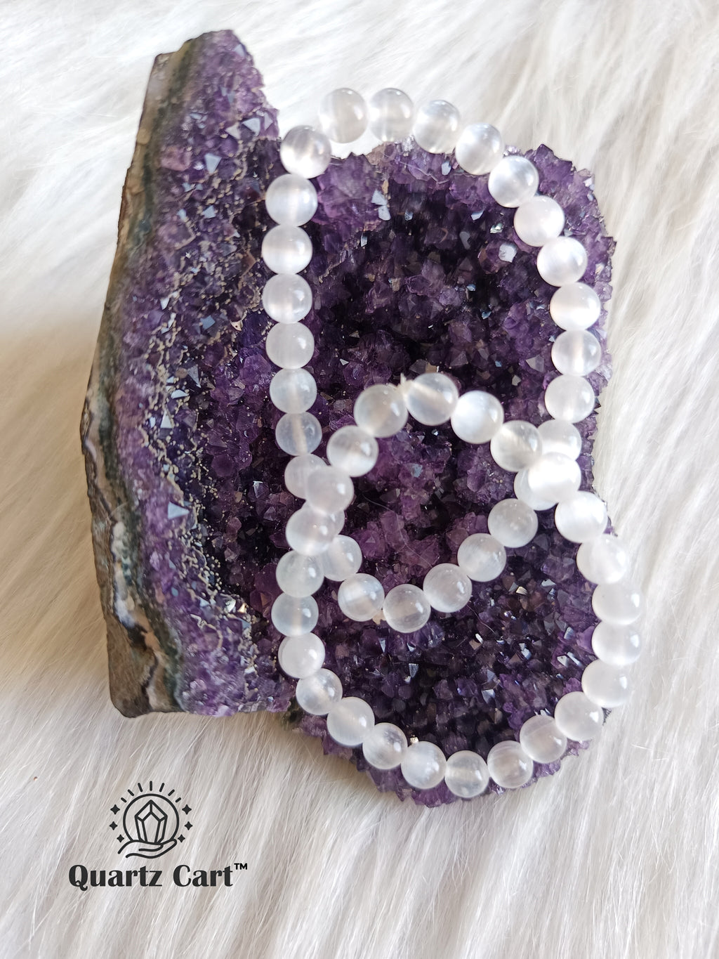 Two natural selenite bracelets placed on amethyst crystal cluster, healing crystal jewelry for energy cleansing and spiritual protection