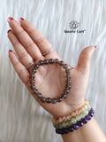 Smoky quartz round bracelet held on hand showing natural brown gemstone beads, healing crystal bracelet for protection, grounding and emotional balance