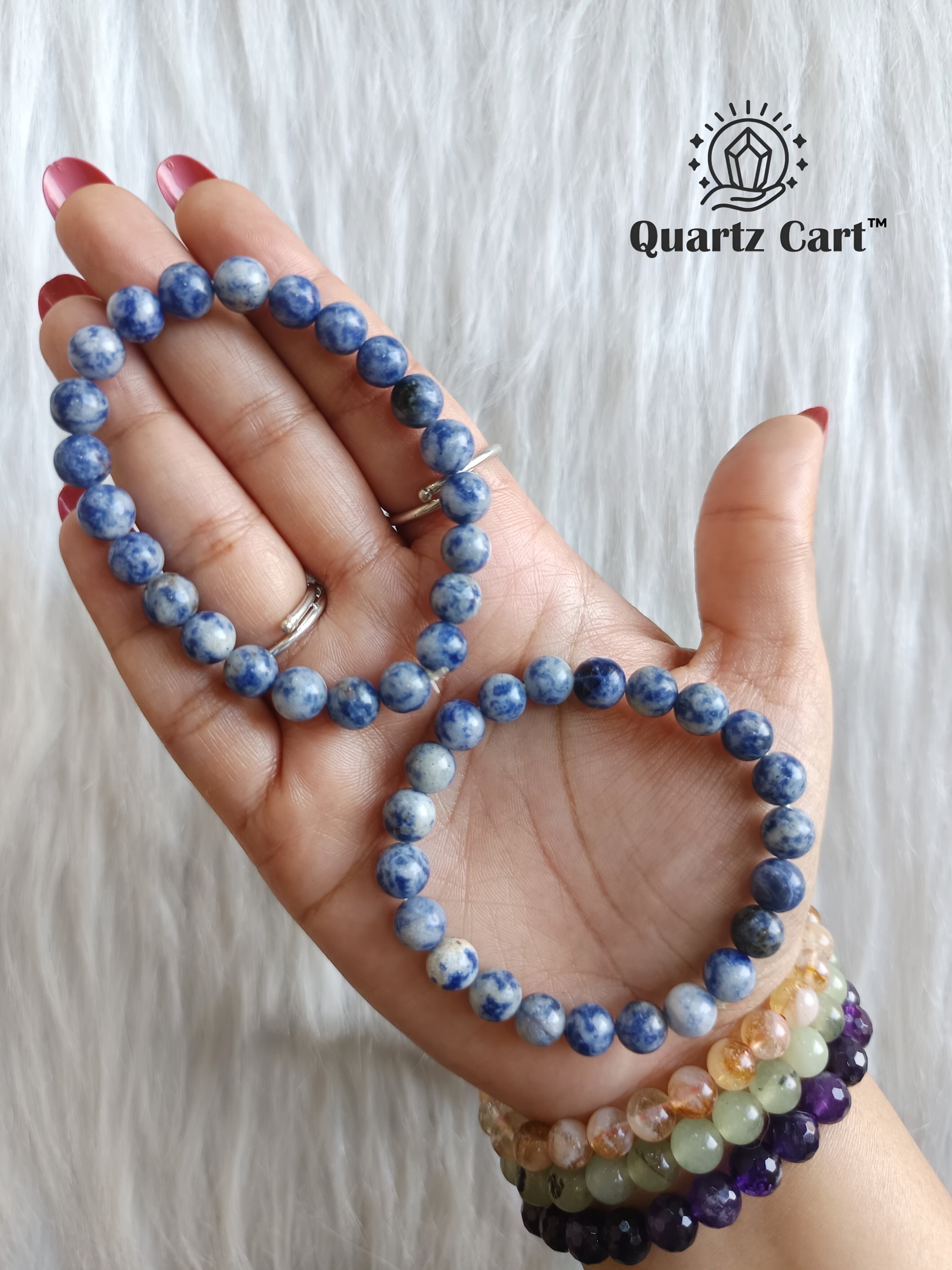 Hand holding Sodalite healing crystal bracelet for mental clarity communication and emotional balance