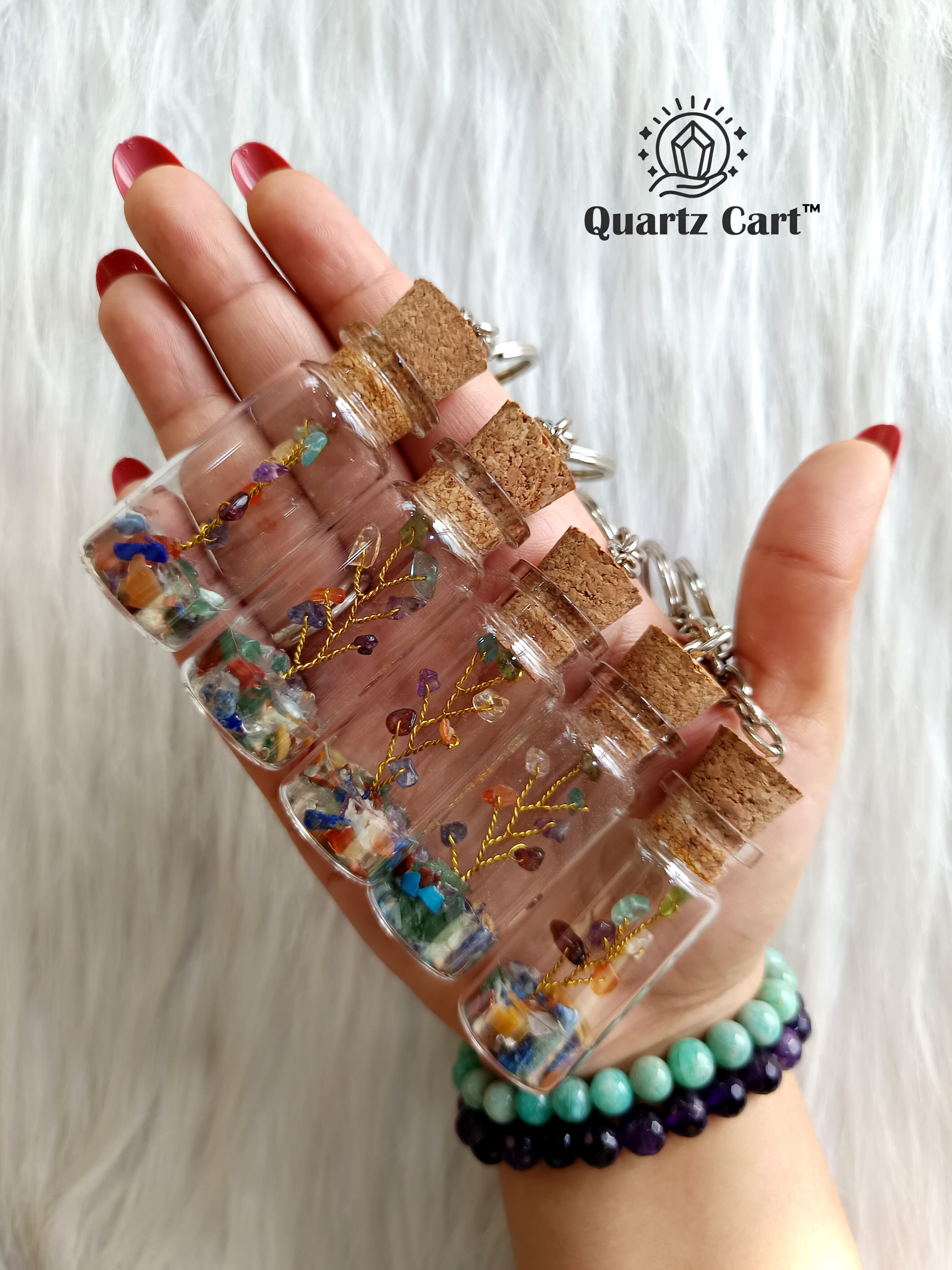 colorful stone chips bottle keychains displayed on hand