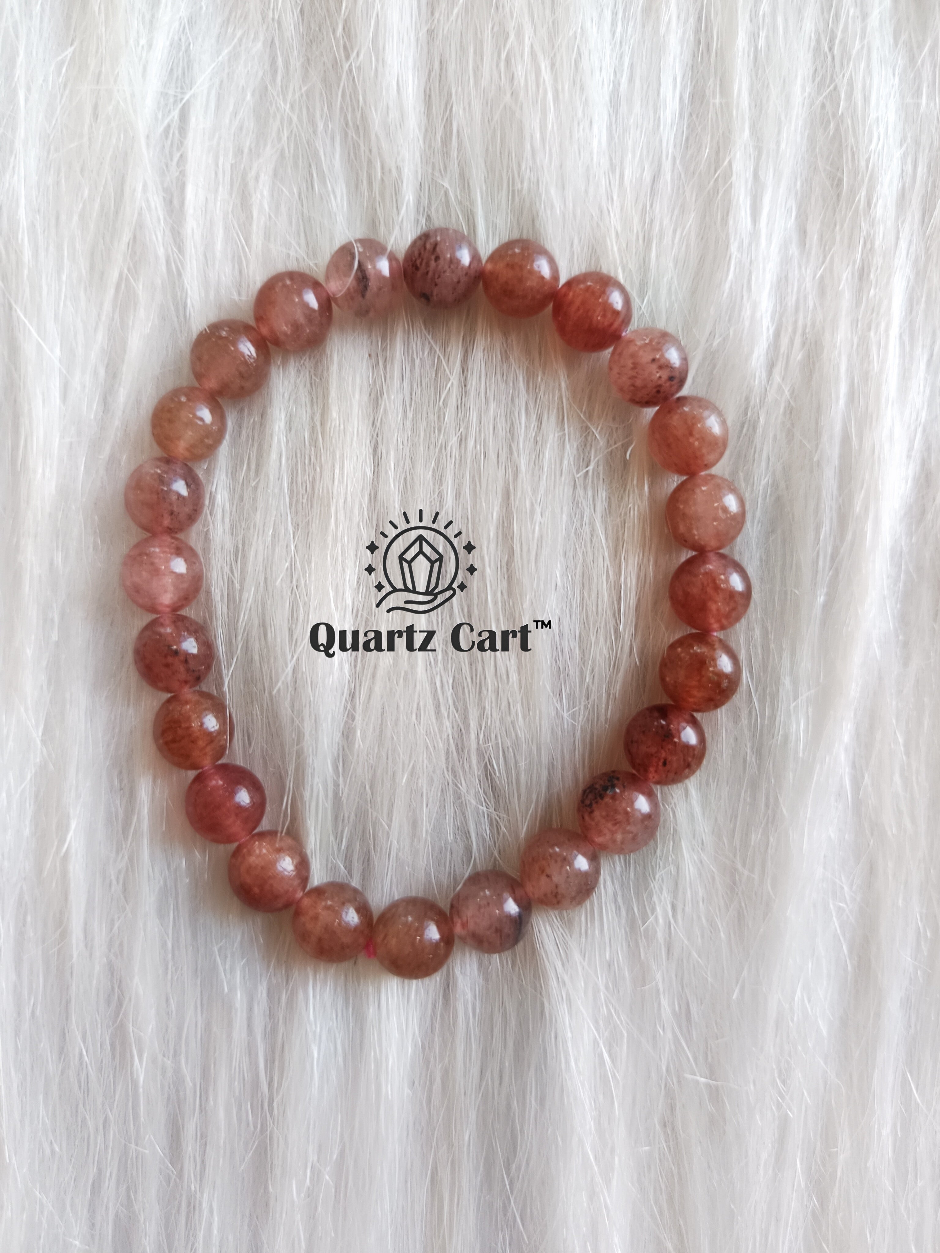 natural strawberry quartz crystal bracelet placed on surface for self love positivity and emotional balance