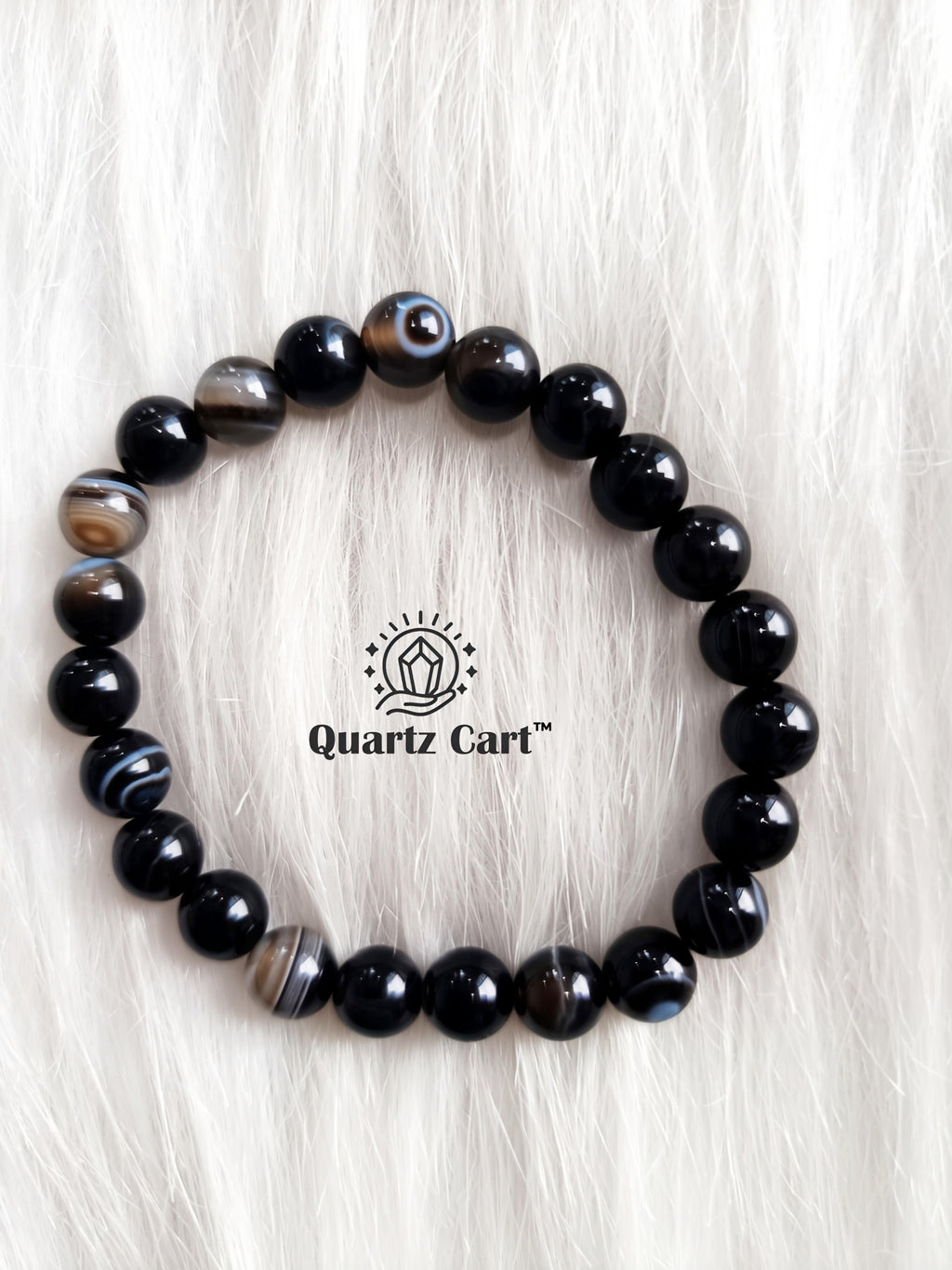 Sulemani Haqiq bracelet displayed on soft surface showing natural black gemstone beads, healing crystal bracelet for protection and positive energy