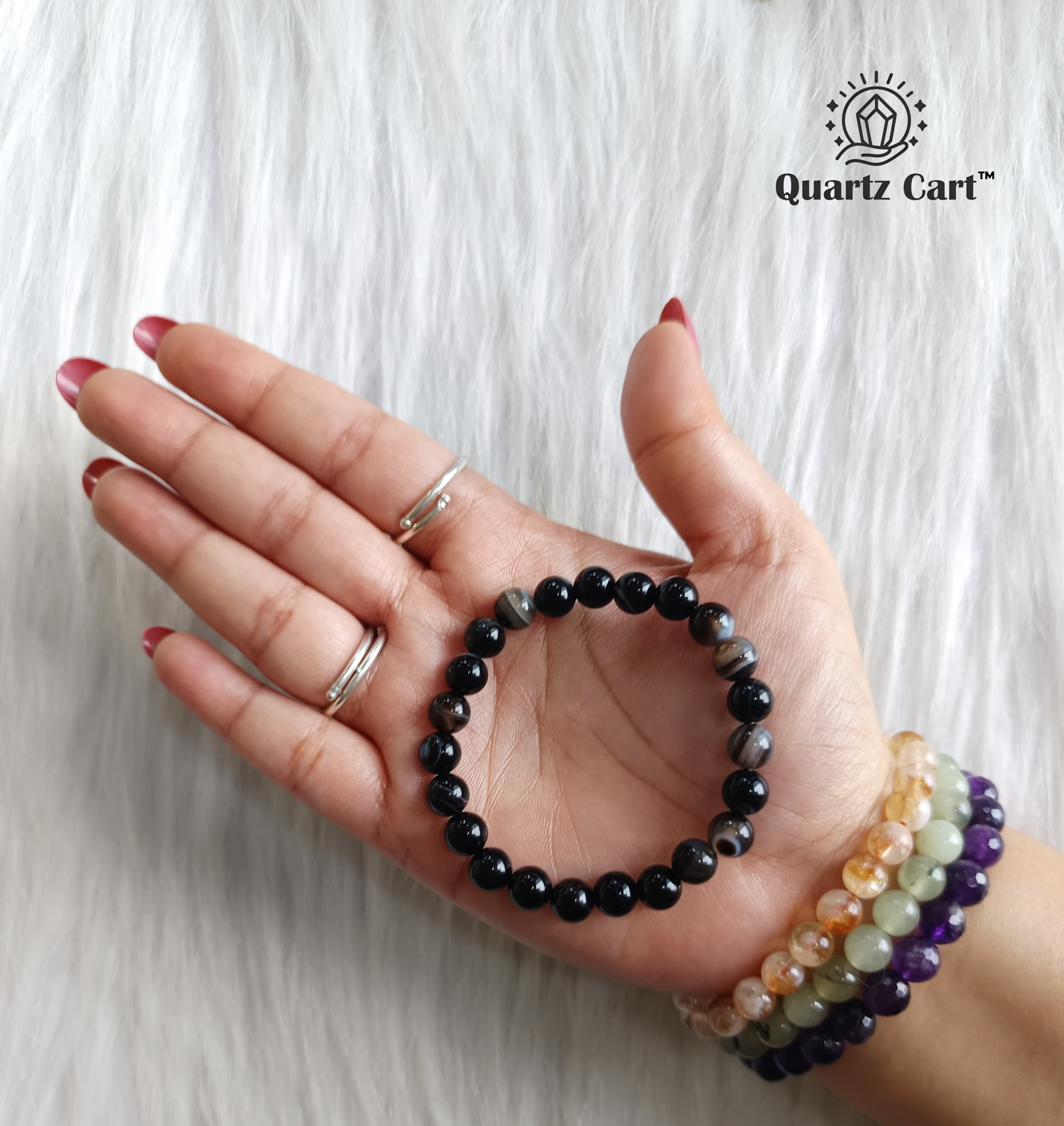 Sulemani Haqiq bracelet held on hand displaying natural black gemstone beads, crystal bracelet for protection, strength and spiritual balance