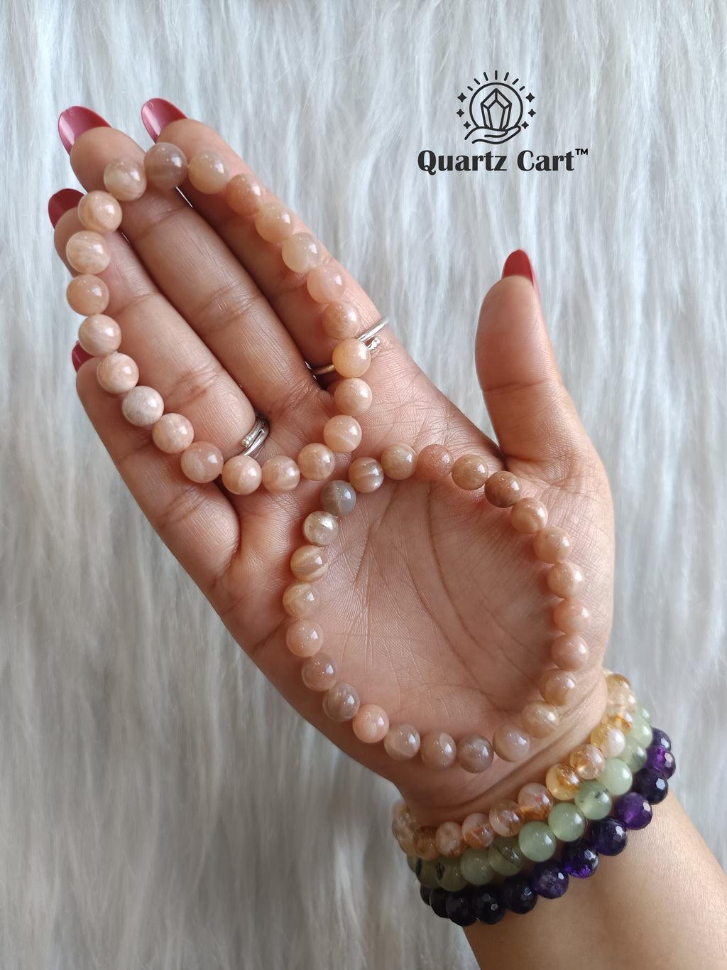 Hand holding natural Sunstone healing crystal bracelet for confidence and positive energy