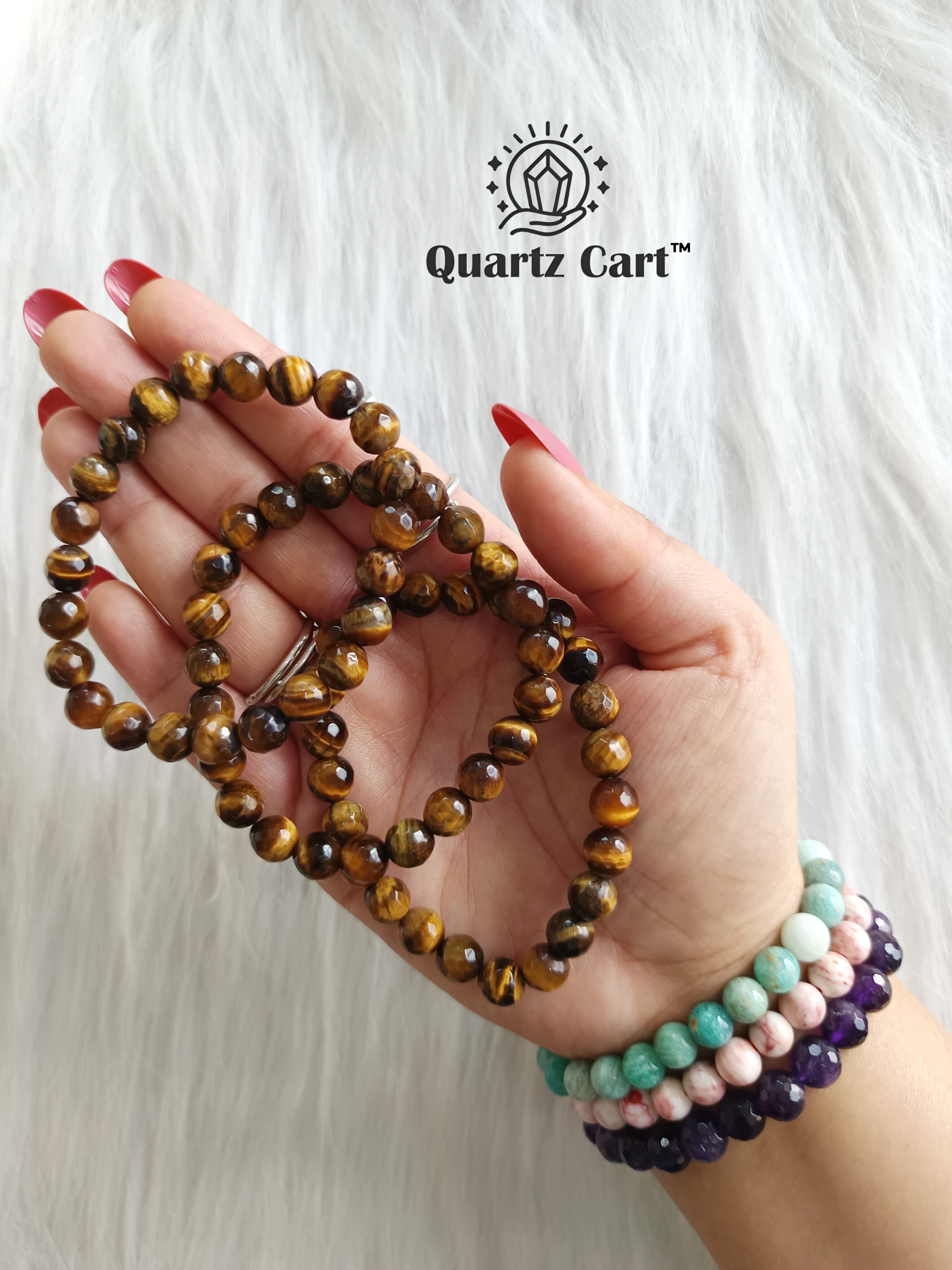 Hand holding Tiger Eye faceted healing crystal bracelets for confidence protection and focus