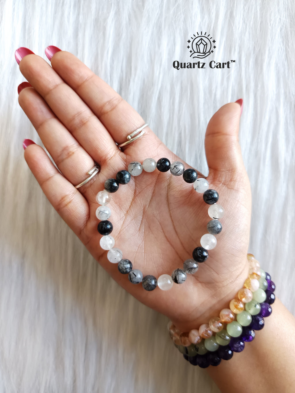 Tourmalinated quartz bracelet placed on palm with black and clear crystal beads for protection, clarity and energy balance