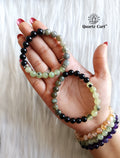 Hand holding Triple Protection Healing Crystal Bracelet with natural protective gemstones